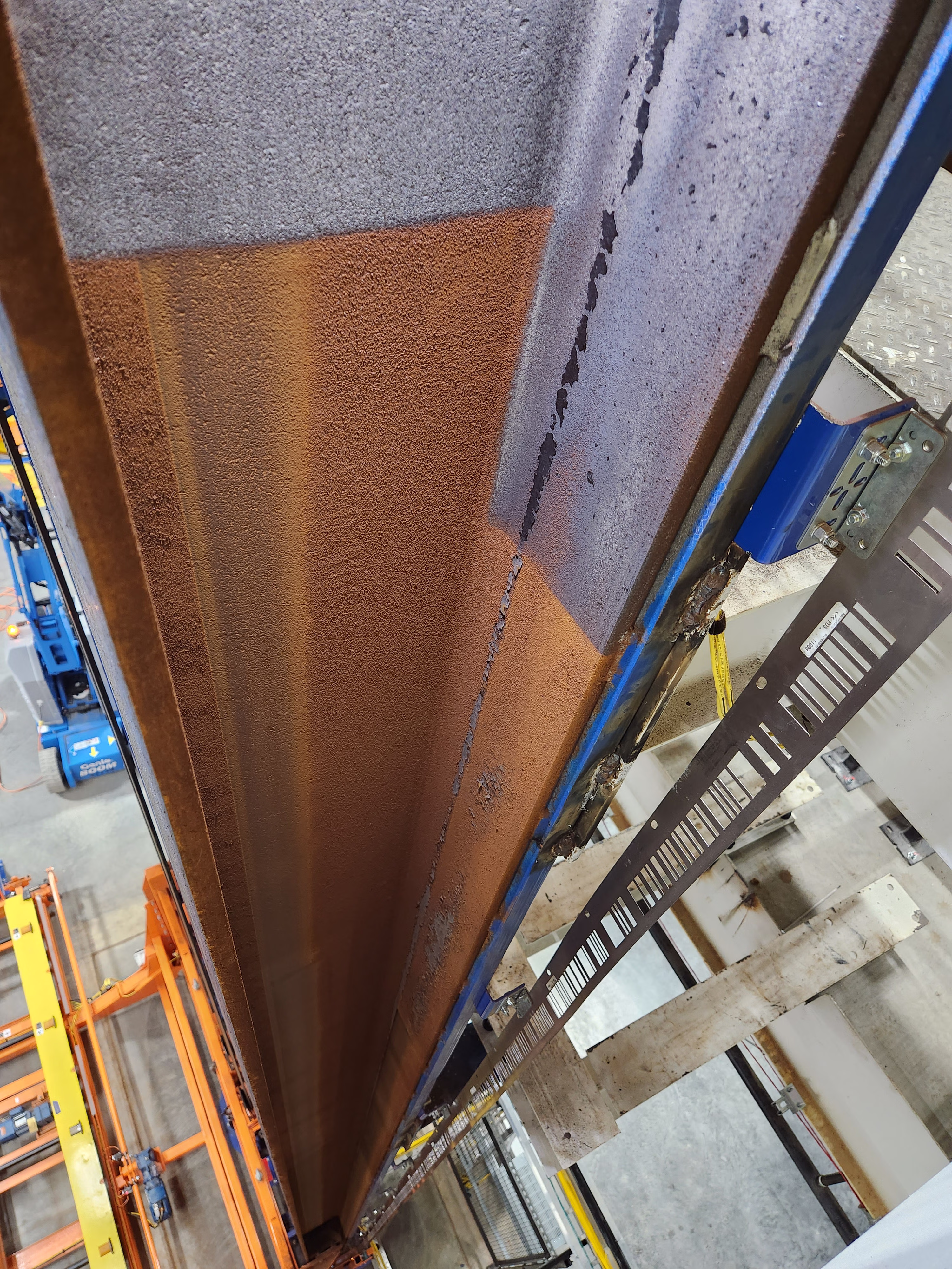 I-Beam rust removal in warehouse.